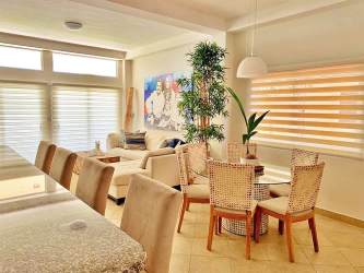 Modern open plan living and dining area with light decor and breakfast bar at Playa La Barqueta Panama