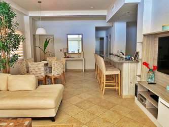 Three-story Mediterranean architecture condo building with swimming pool and palm trees in Las Olas Playa La Barqueta Panama