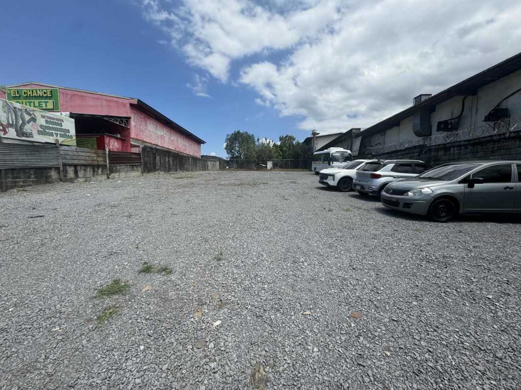 Large gravel parking lot with warehouse buildings around in Pedregal, Panama City