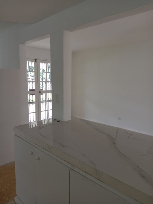 Marble countertop white kitchen with open dining area and glass doors Villa Zaita Panama