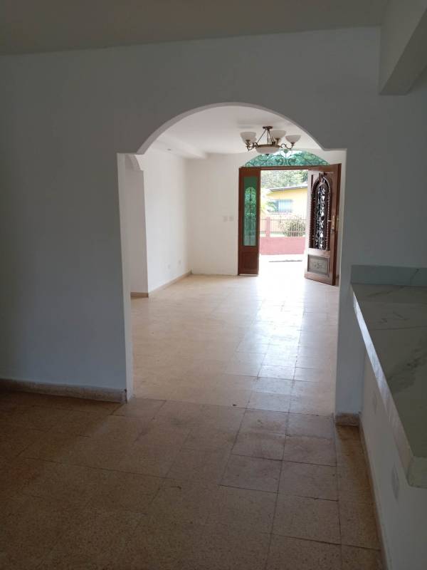 Large living room with tiled flooring, wooden door, natural light in Villa Zaita house for sale Panama