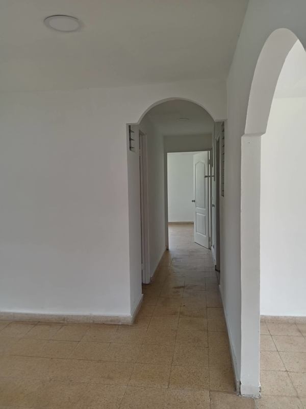 Interior hallway with white walls, arched doorways and tile flooring in Villa Zaita house Panama