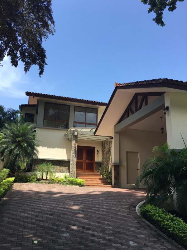 Outdoor covered patio overlooking landscaped backyard with pool in luxury Panama house