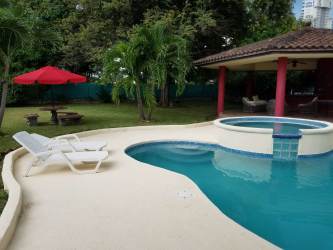 Private swimming pool with jacuzzi, sun deck, lush landscaping at Coronado Golf home