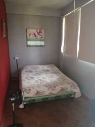 Bedroom with window AC, tiled flooring, beds and ample space in beach house Coronado Panama