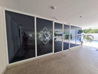 Modern well-lit gym with glass walls overlooking pool Playa Corona Residence Panama
