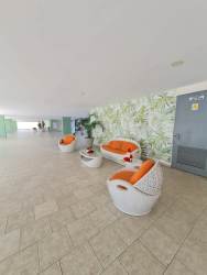 Compact kitchen with wood cabinetry, stove, microwave in Playa Corona beachfront apartment Panama