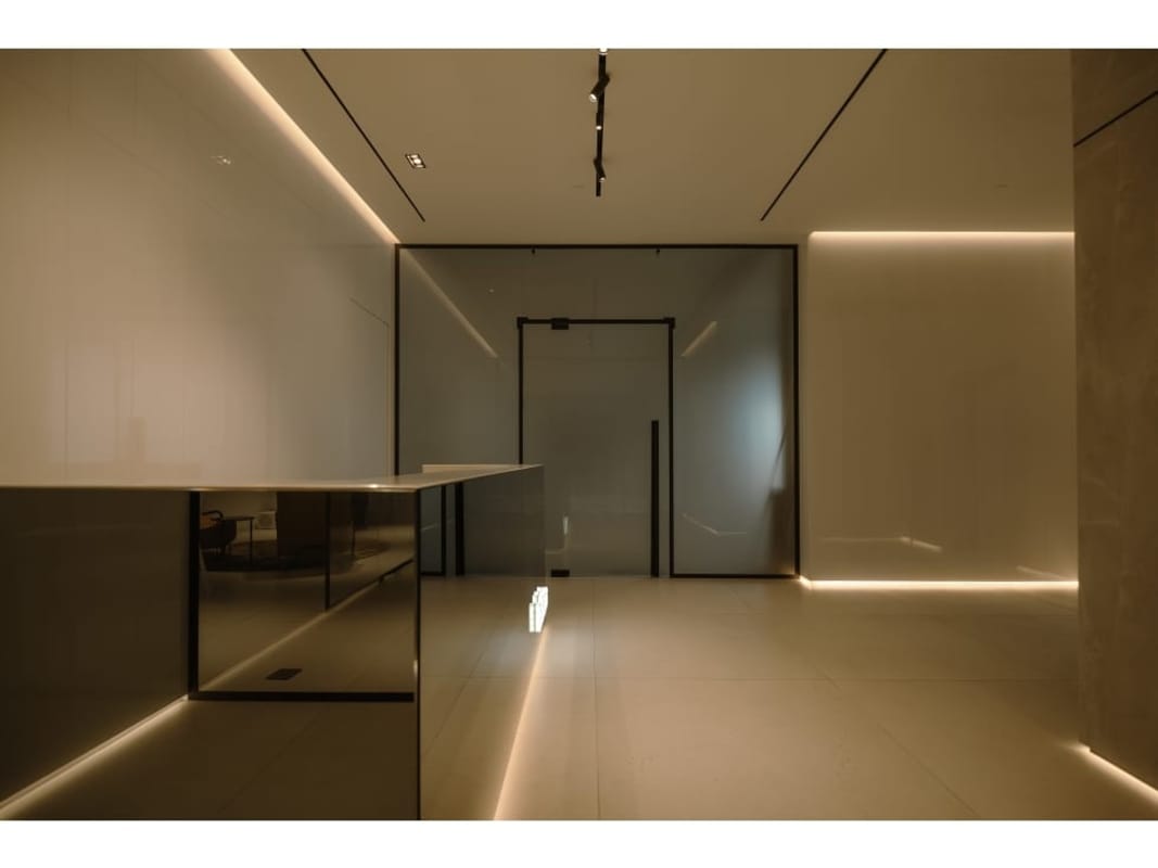 Minimalist lobby with high-gloss finishes, reception desk and lighting at Armani Casa tower Panama City