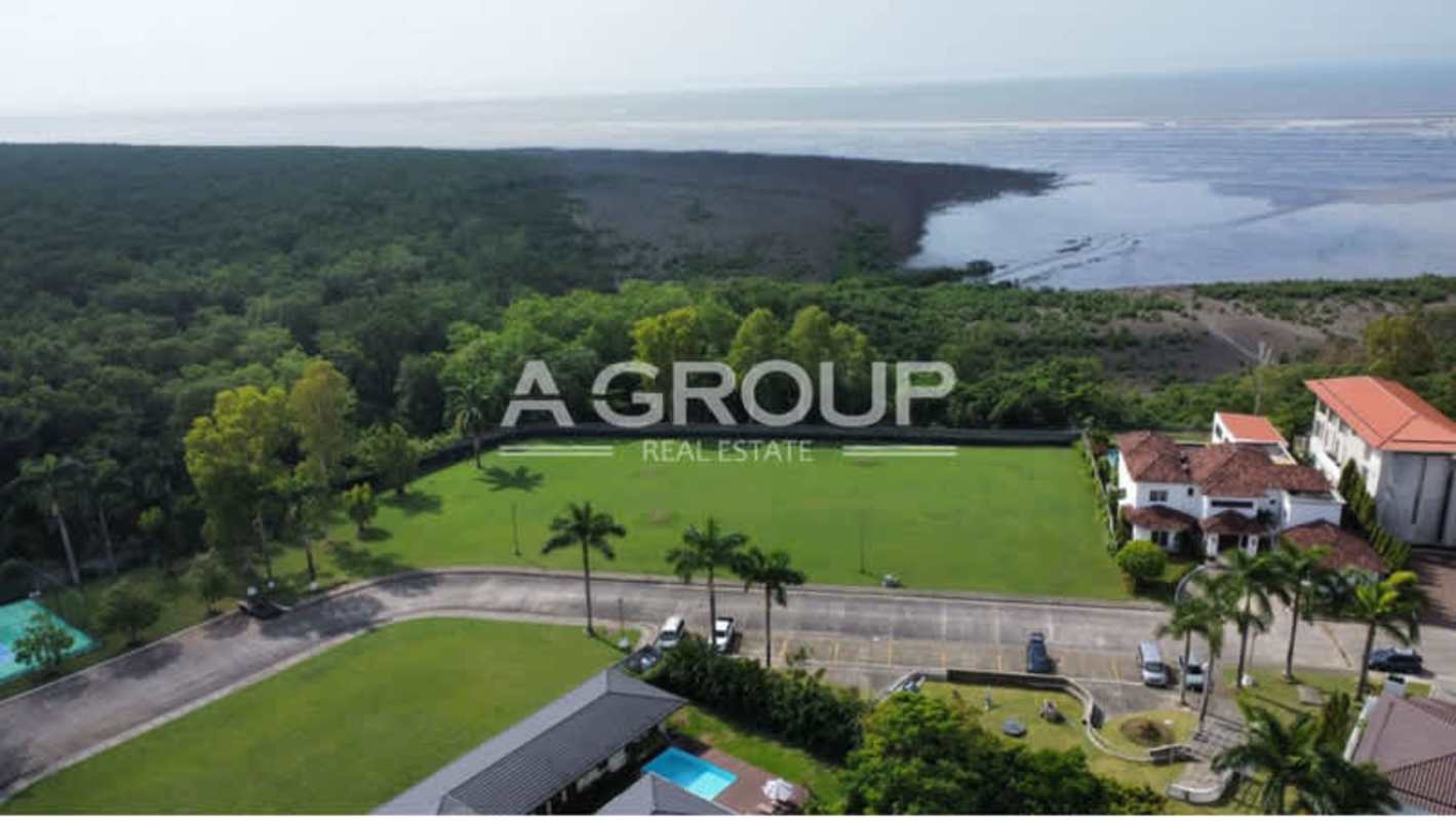 Aerial panorama of Villas del Mar in Costa del Este with beachfront view, landscaped lawns, swimming pool, colonial roofs and ocean background