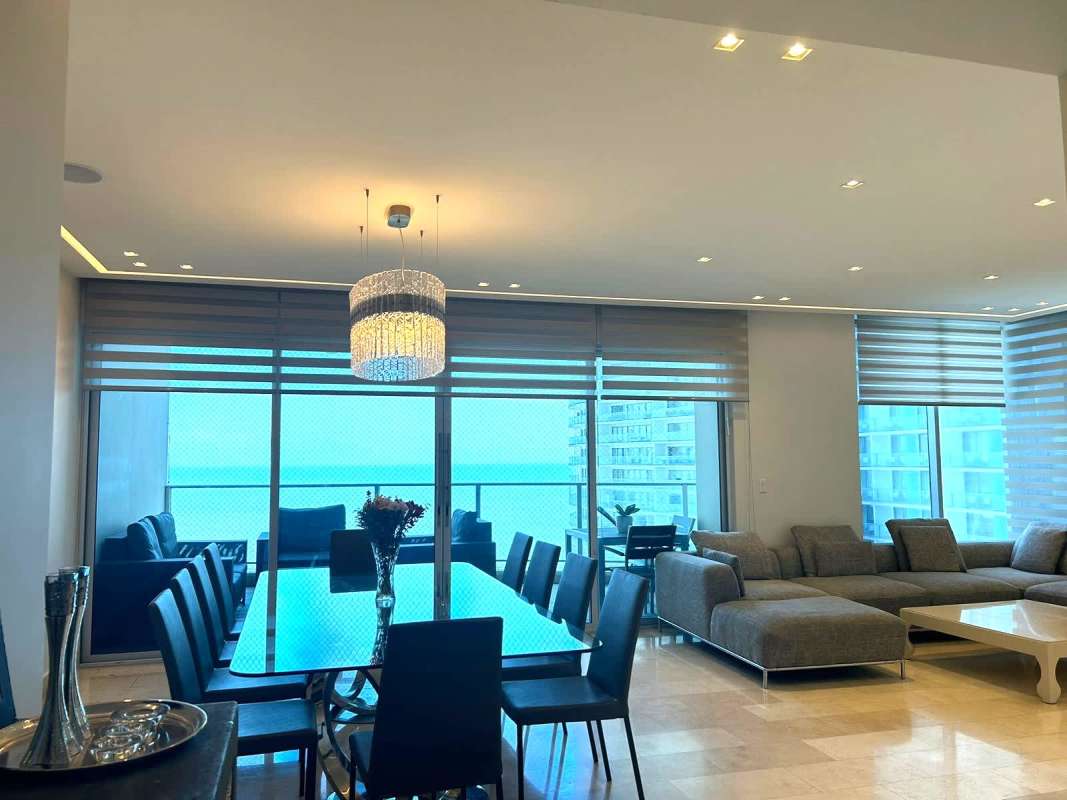 Open concept living and dining room with floor-to-ceiling windows ocean view Pacific Village Punta Pacífica