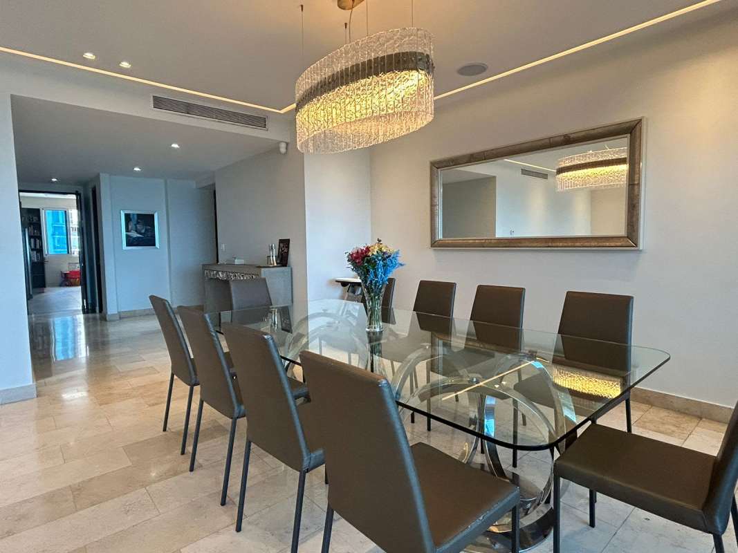 Modern dining room with chandelier and marble floor at Pacific Village apartment Punta Pacífica