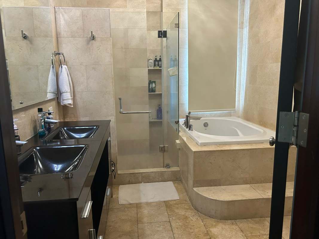 Modern bathroom with double sinks, glass shower, bathtub at PH Pacific Village