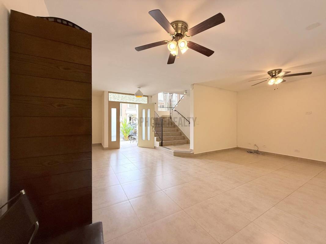 Bright living room with sliding glass door, ceiling fan, tiled flooring in Clayton Panama rental home