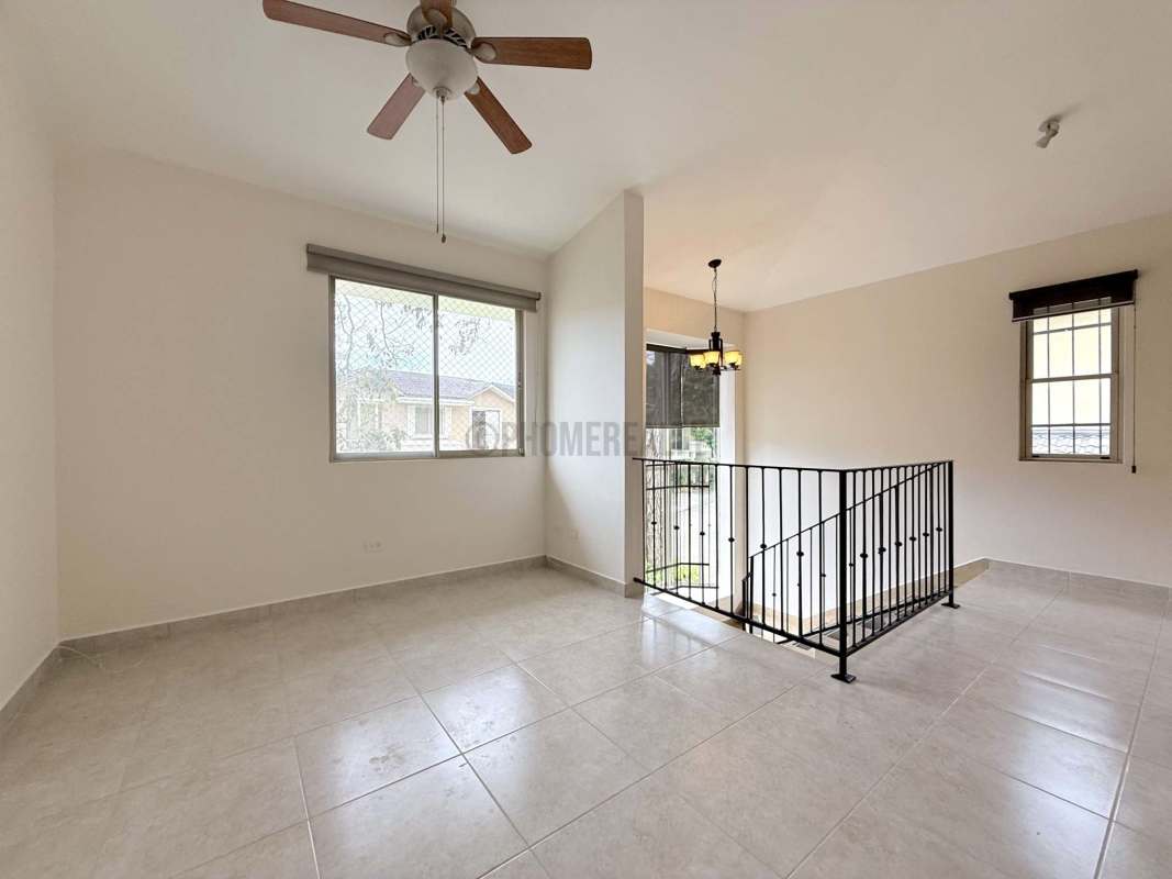 Bedroom with large window, built-in wooden wardrobe, neutral tiles rental house Clayton Panama