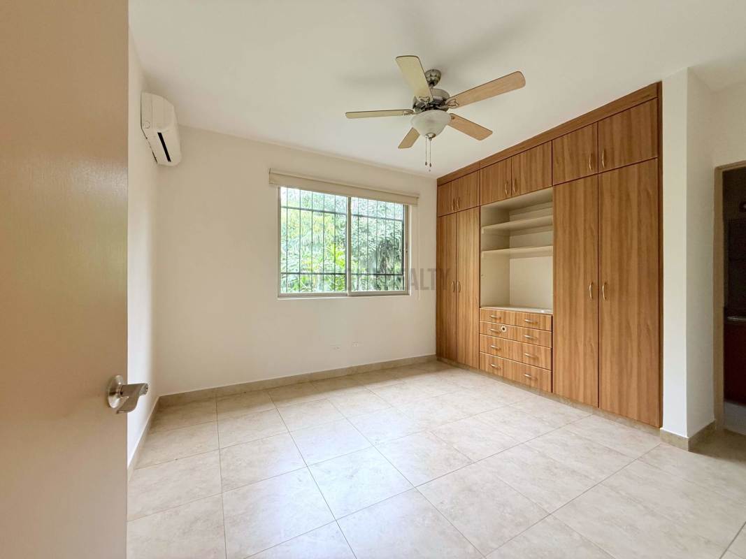 Modern bathroom with beige tiles, glass shower, granite counter in Clayton Panama rental house