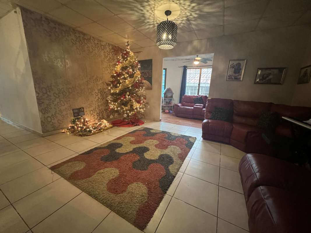 Living room with red sectional sofa, large windows, and holiday decor in Ciudad del Lago Ernesto Córdoba