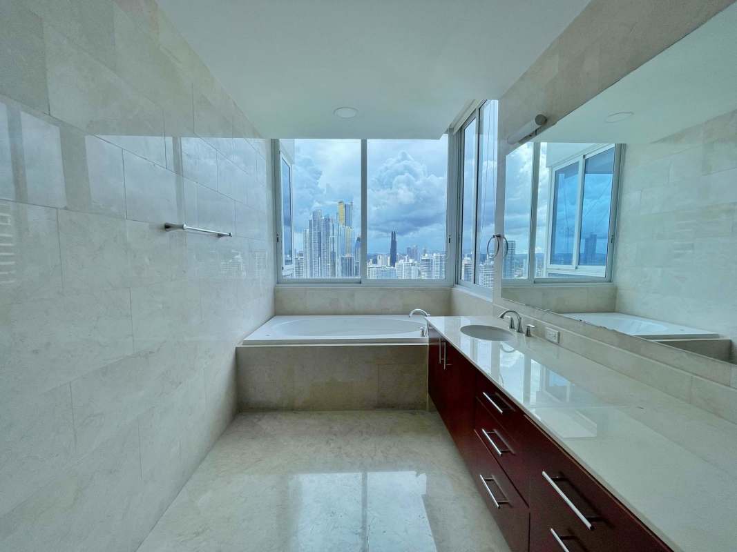 Luxury master bedroom with floor-to-ceiling ocean views and marble finishes at PH The Point, Punta Paitilla