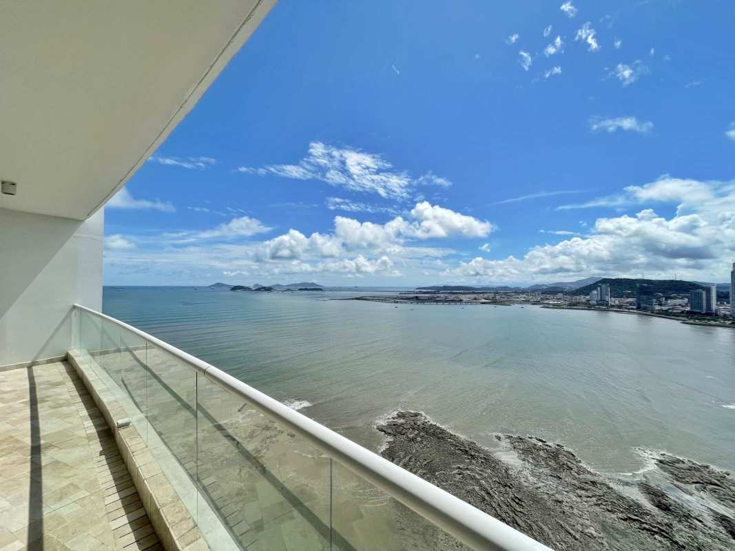 Luxury kitchen with granite island, wood cabinetry, panoramic city and ocean views at PH The Point Panama