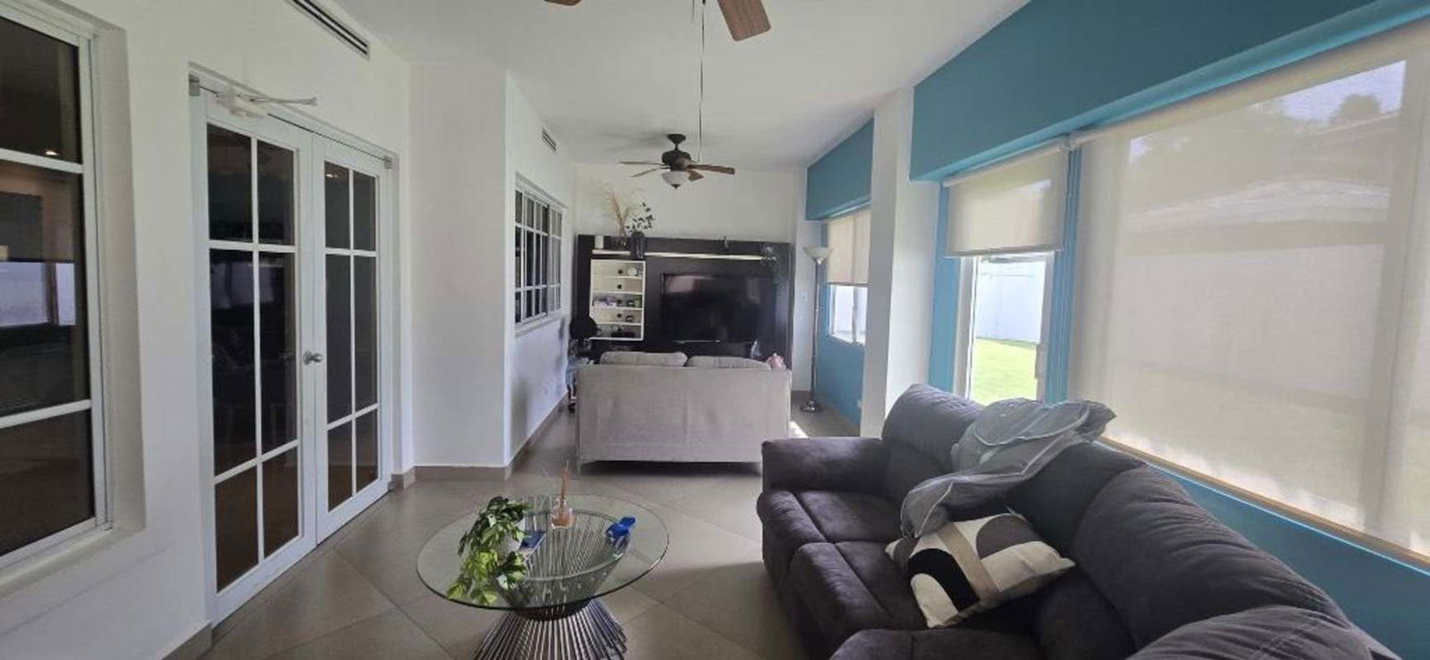 Bright living room with sectional sofa, large windows and garden views Palmeras del Este Panama