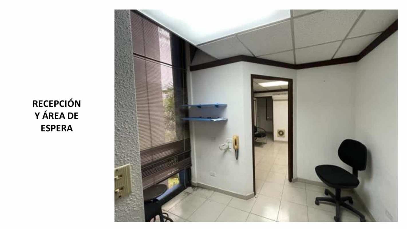 Reception corner in medical office, window with blinds, phone, shelving in PH Policlínica Norte