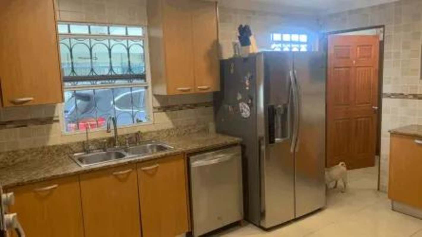 Modern kitchen in house for sale with granite countertops, wood cabinetry, stainless appliances in Nuevo Reparto Chanis Panama