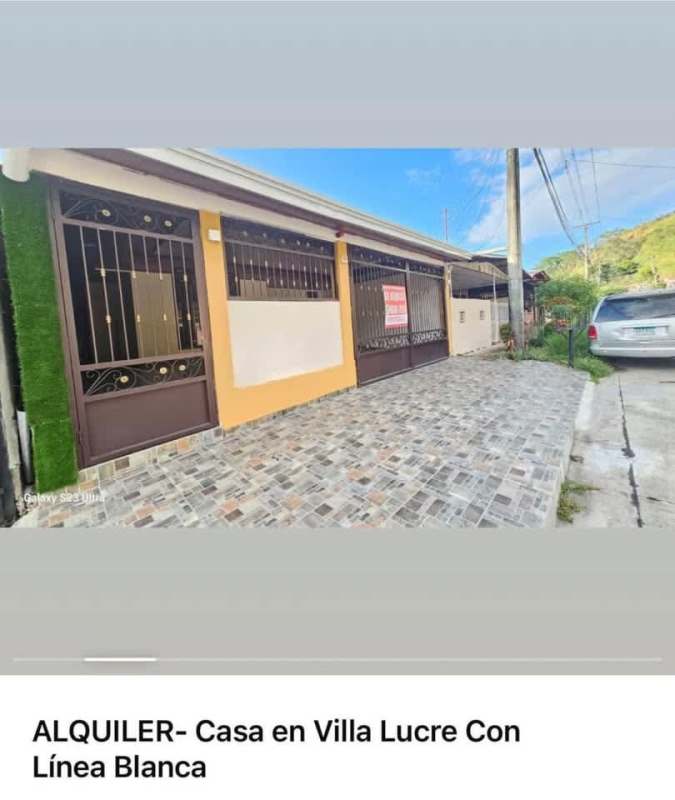 Single-story house with yellow walls, metal gates, tiled driveway for rent in Villa Lucre Panama