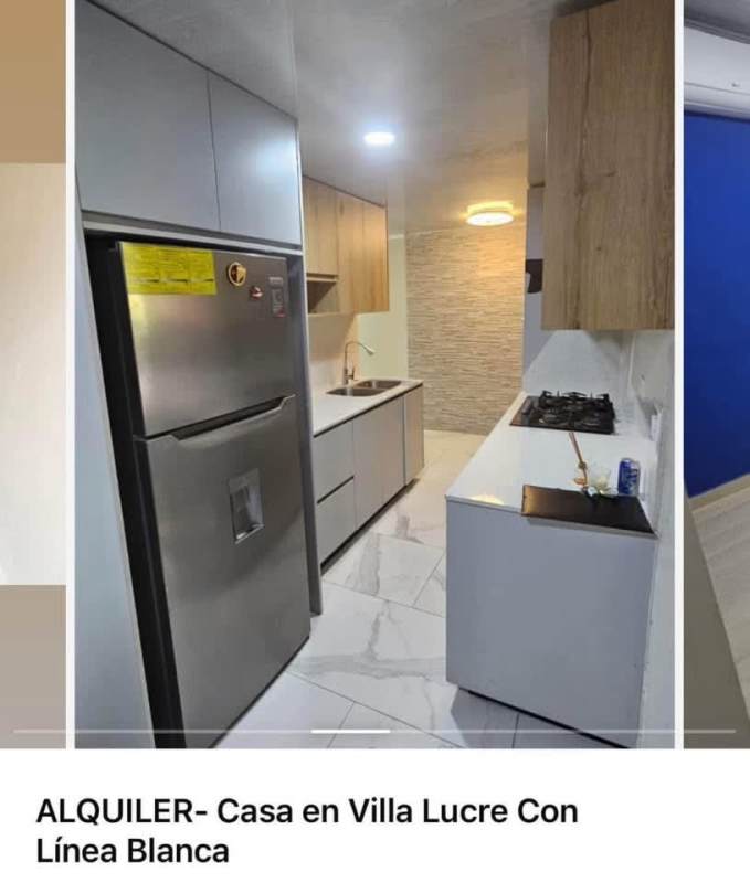 Bright modern narrow kitchen with stainless steel refrigerator, gas stove, light wood cabinetry in Villa Lucre house for rent