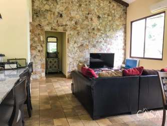 Living room with stone accent wall, sectional sofa, TV, large window Provence style