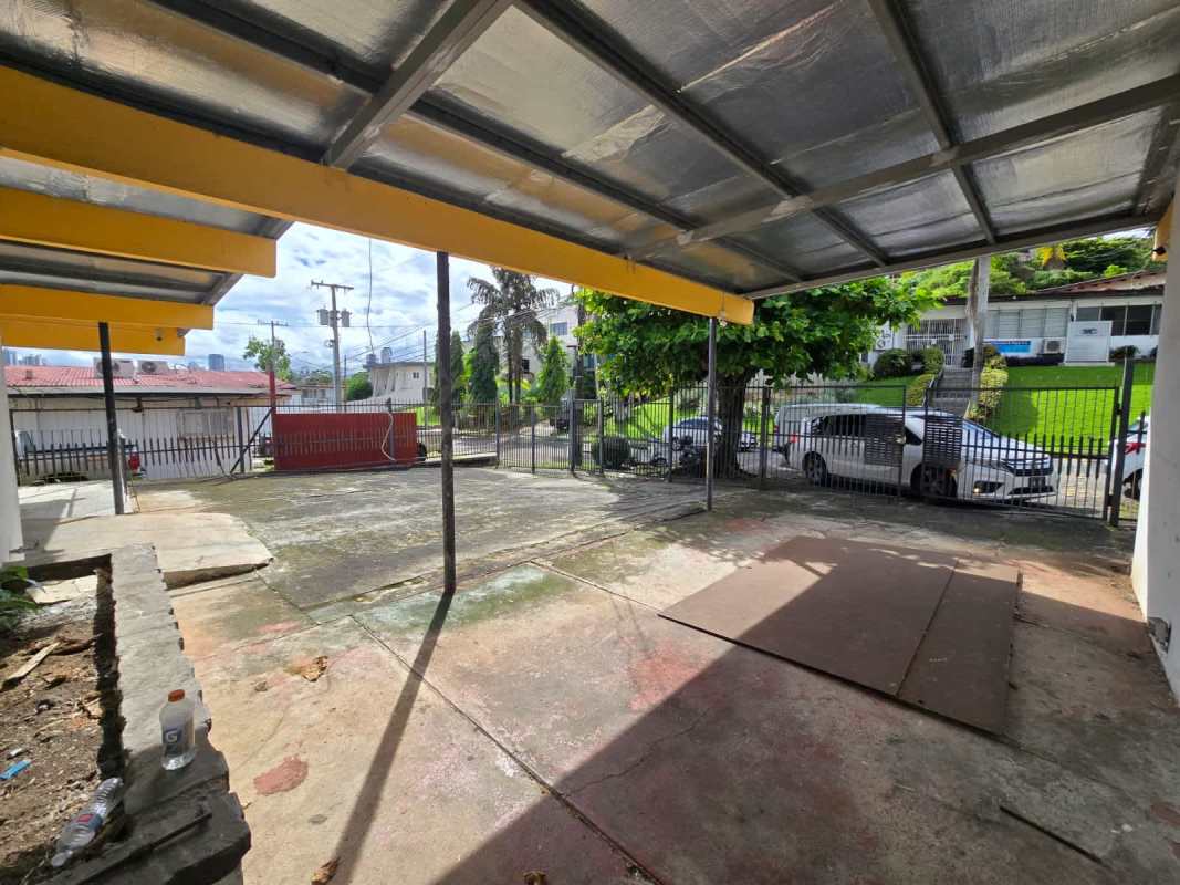 Street view showing fenced outdoor space and car entry Los Ángeles Panama City