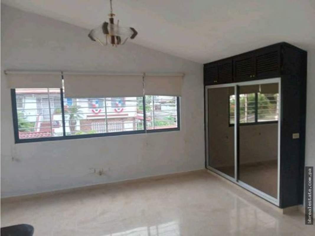 Bedroom with mirrored closet, roller blinds, vaulted ceiling, and marble flooring in house for rent Betania Club X Panama