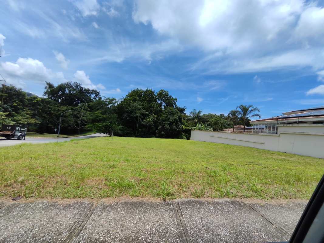 Vacant lot bordered by sidewalk and residential building Albrook Panama City