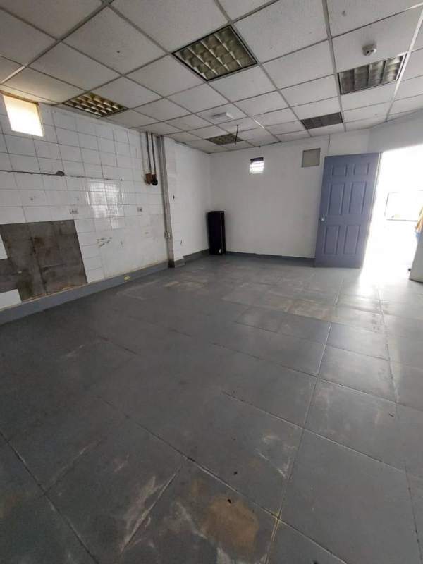 Empty room with tiled floor, tiled walls and suspended ceiling lights in commercial property Juan Díaz Panama