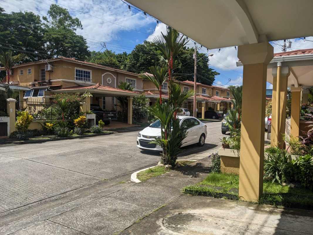 Spacious living room with large windows, ceiling fan, tiled floors and red accent wall in Dorado Lakes townhouse