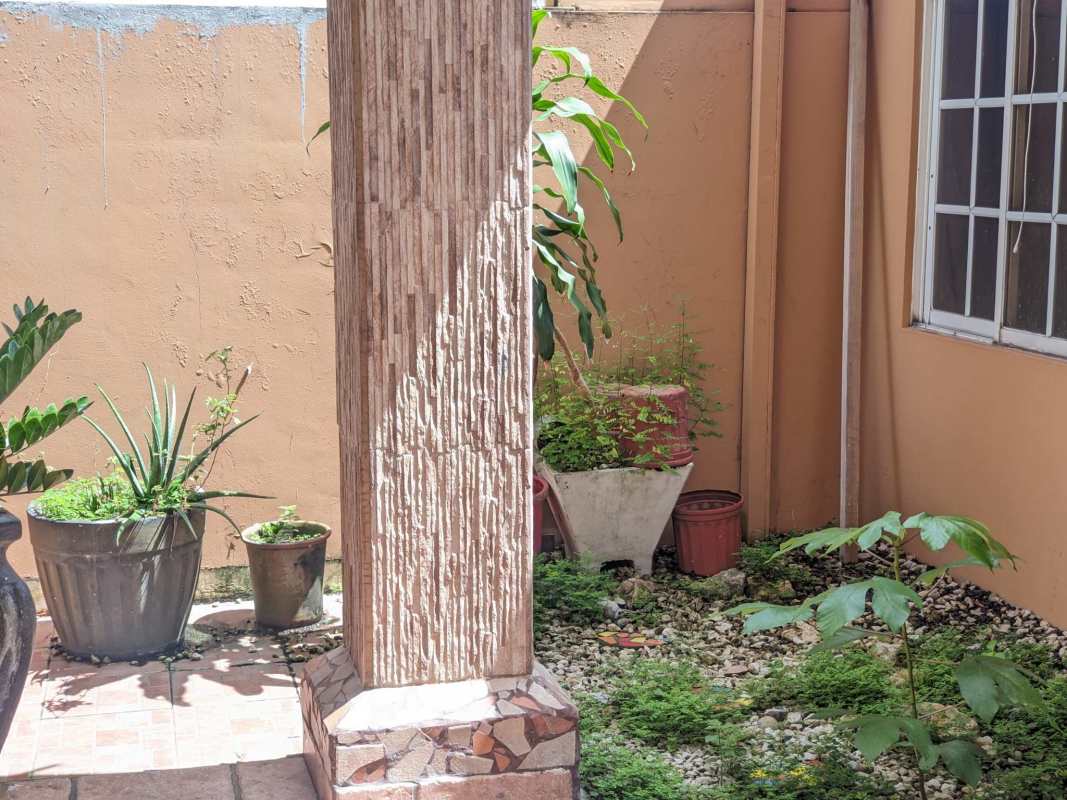 Kitchen featuring cream cabinets, tile backsplash, double sink, granite style countertop, and fan in Condado del Rey townhouse