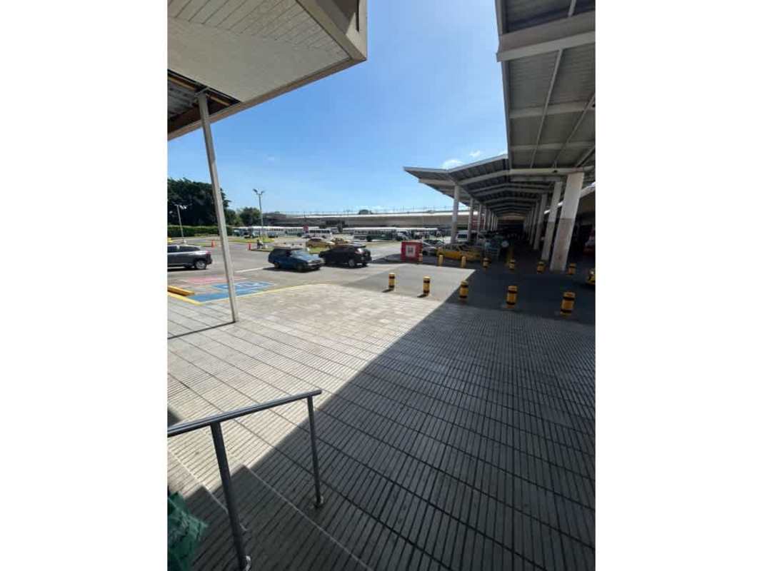 Covered commercial center walkway with parking spaces and drive lanes at 24 de Diciembre Panama