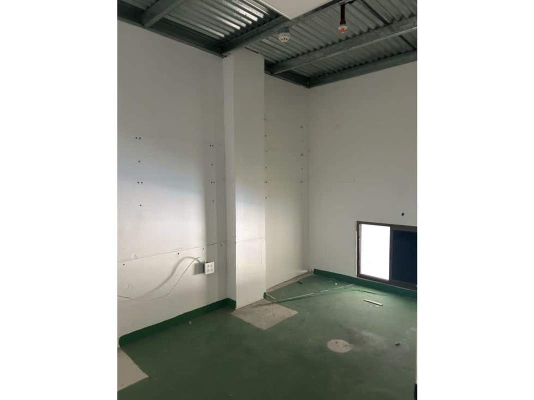 Unfinished warehouse utility room with exposed ceiling and green floor La Doña Panama