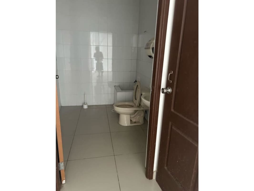 Simple tiled restroom with toilet and sink inside commercial unit 24 de Diciembre Panama