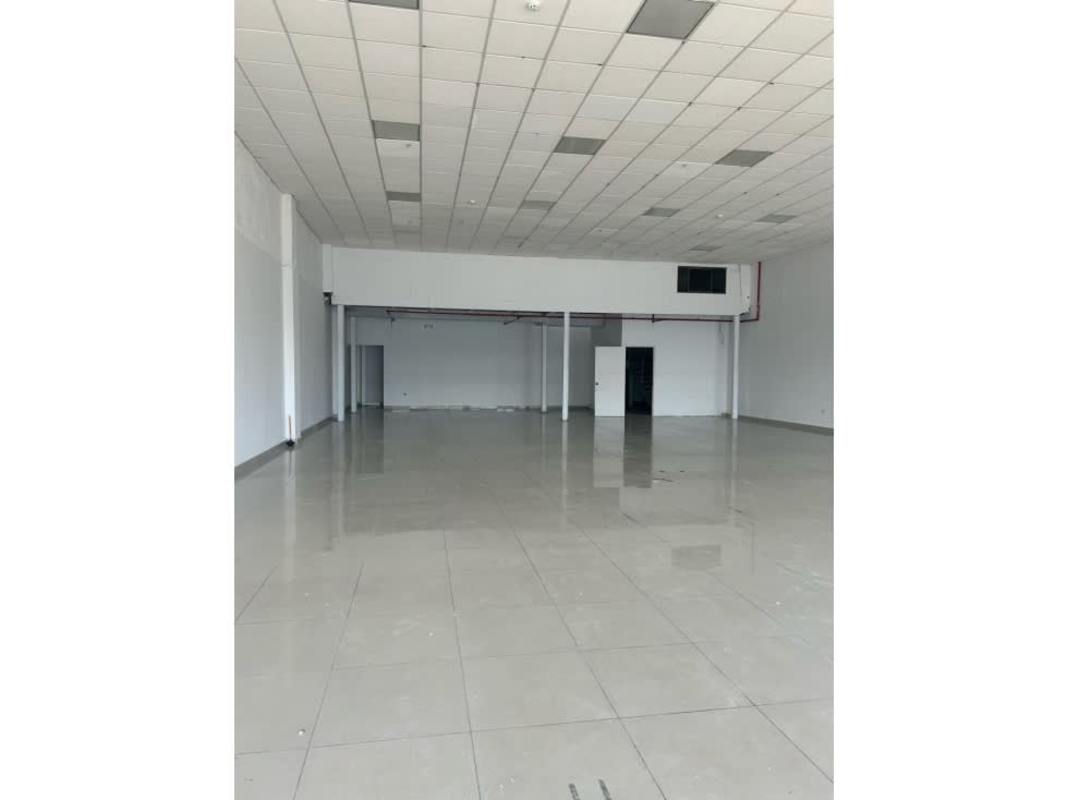 Large retail commercial interior with tiled floor, white walls, high ceilings, mezzanine