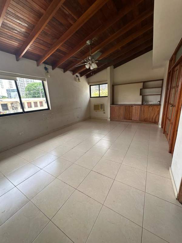 Living room with vaulted wood ceilings, tile floors, large windows at Altos de Golf luxury house Panama
