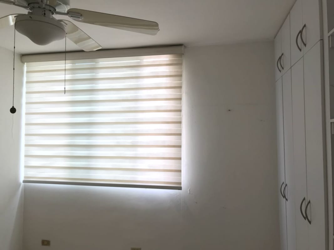 Bedroom with built-in wardrobe, ceiling fan, striped blinds at PH El Cangrejo Park View Panama City