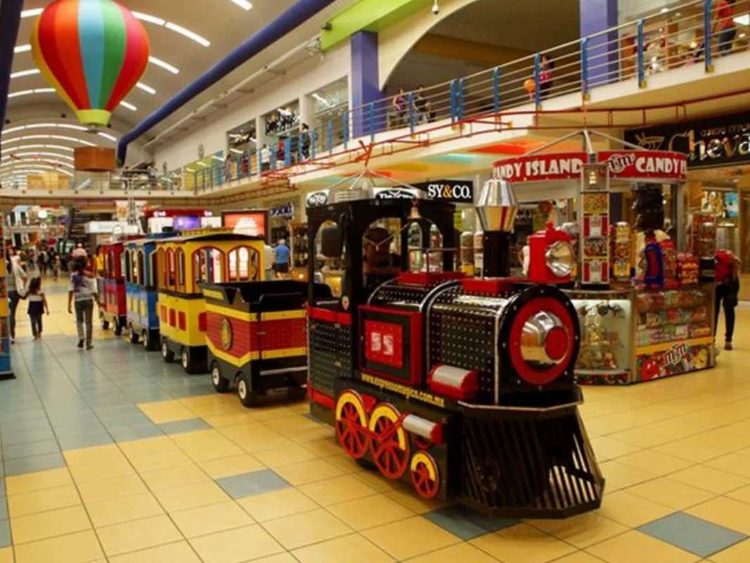 Retail unit interior with columns, signage, lighting and air conditioning ducts at Albrook Mall Panama City