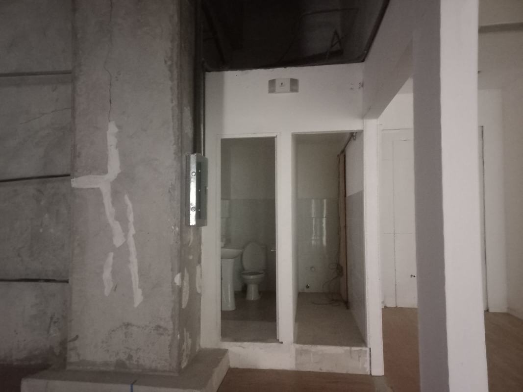 Unfinished commercial interior showing concrete pillar and bathroom with toilet in Albrook Mall Panama