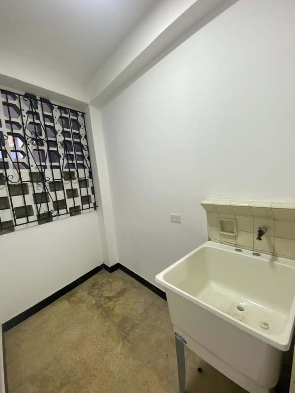 Laundry area with white sink, barred window and tiled backsplash at PH Don Goyo