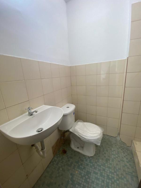 Small bathroom with walk-in shower, tiled walls, ceramic sink and toilet - PH Don Goyo