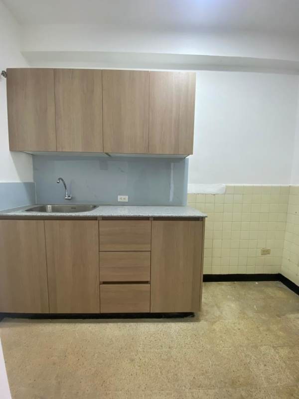 Kitchen with wooden cabinets, stainless sink and neutral backsplash at Don Goyo Calidonia