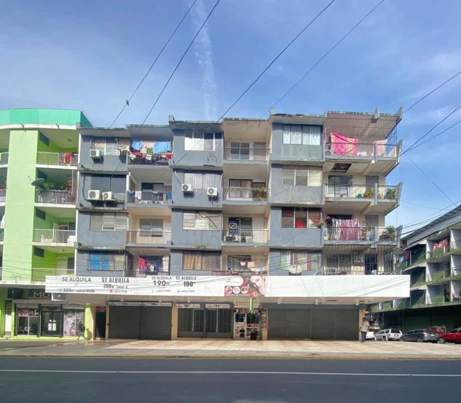 Multi-story apartment building with balconies and ground level shops PH Don Goyo Calidonia