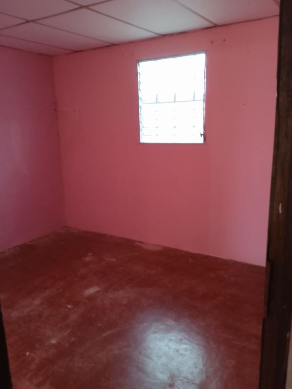 Bedroom with tiled ceiling, barred window, simple finishes affordable Panama house