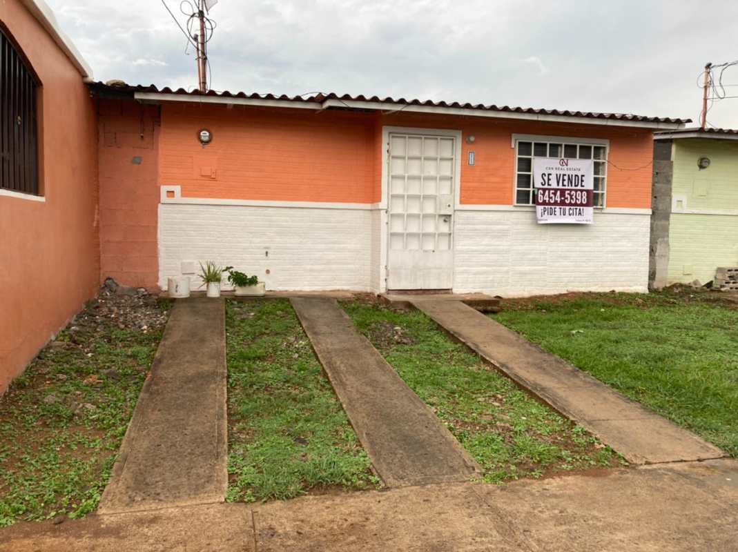 Living room with tiled floor, pink walls, and drop ceiling in affordable Tocumen Panama house
