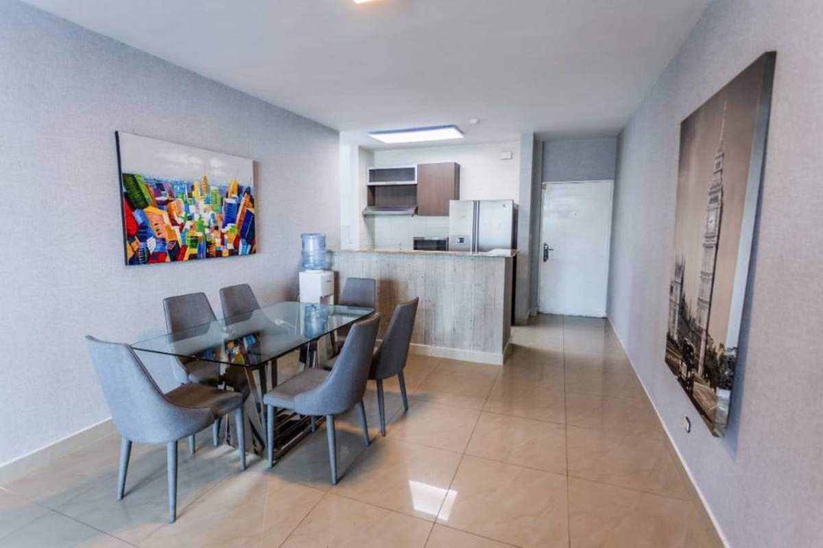 Contemporary dining with gray chairs, glass table, compact kitchen in Pacific Sky Punta Pacifica Panama
