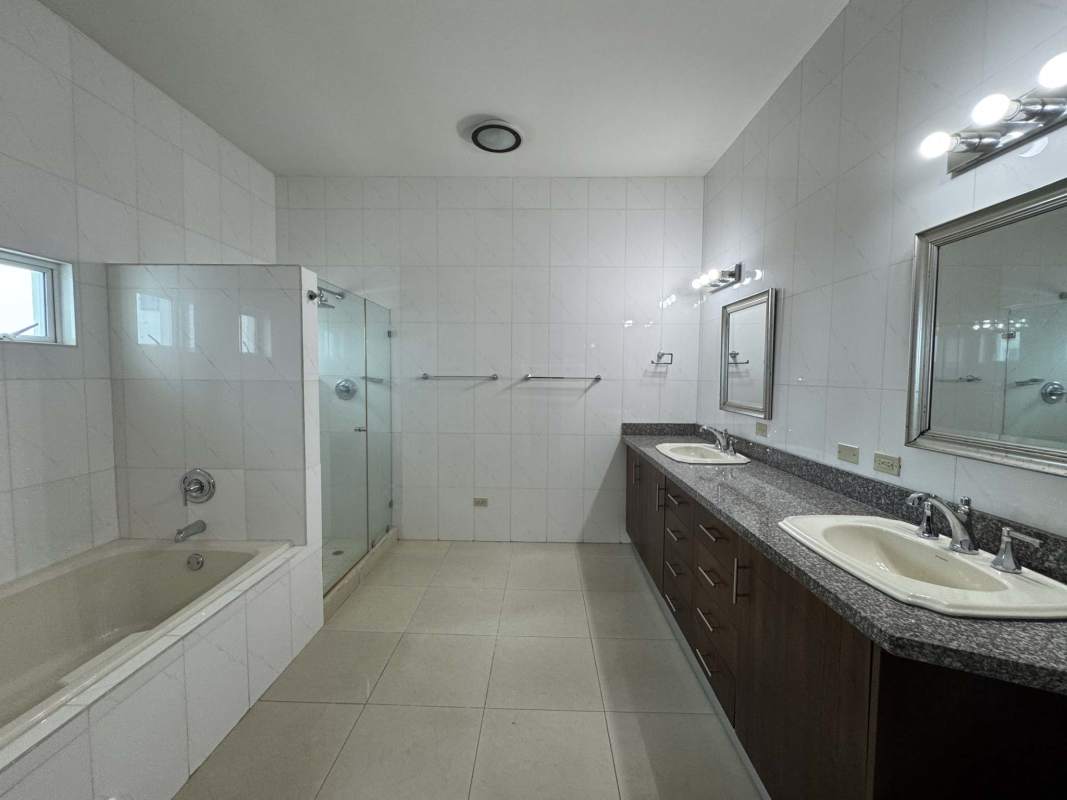 Modern bathroom with granite double sinks, shower and bathtub at Torre Zeus Costa del Este Panama